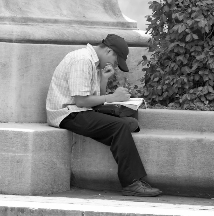 boy reading by fountain